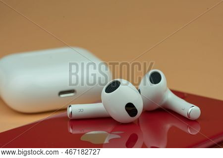 Bangkok, Thailand - December 14, 2022 : Airpods 3 Generations Put On Red Iphone. Headphones From The