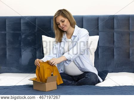 Smiling Pregnant Woman Opens Parcel And Holds Orange Baby Starter Kit, Unisex Baby Long-sleeve Bodys