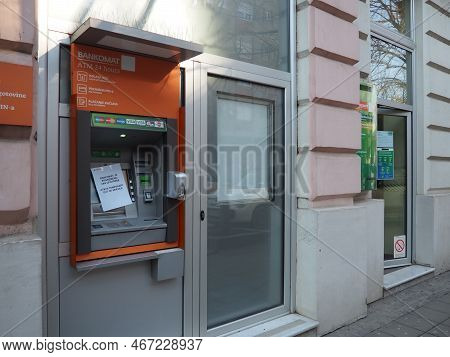 Sberbank. A Depositor Or Client Stands In Front Of The Entrance To The Branch Of A Subsidiary Of Sbe