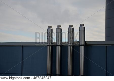 Industrial White Building With Sheet Metal Facade Of Repeating Rectangle Paneling. On Wall Are Two S