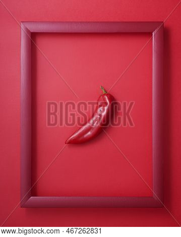 Pepper In Wooden Picture Frame On Red Background