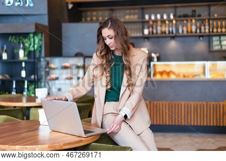 Business Woman Restaurant Owner Use Laptop In Hands Dressed Elegant Pantsuit Sitting On Table In Res