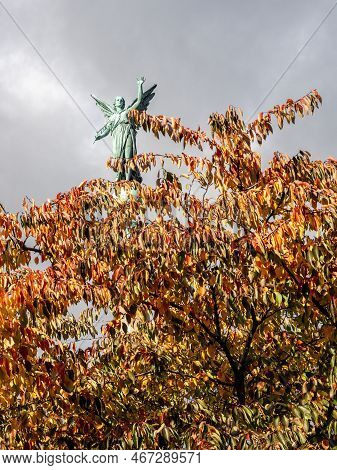 Copenhagen, Denmark - Oct 19, 2018: Bronze Angel Sculpture Of The Ivar Huitfeldt Column Among Autumn