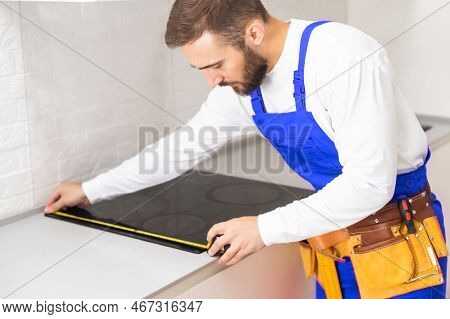 Craftsman Installs Hob In Kitchen. Household Appliance Installation Services Concept