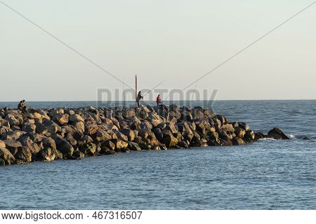 Whanganui New Zealand - April 9 2022; People Fishing Off Rock Groyne At Whanganui River Mouth