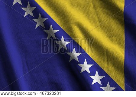 Bosnia And Herzegovina Flag With Big Folds Waving Close Up Under The Studio Light Indoors. The Offic