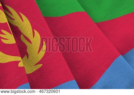 Eritrea Flag With Big Folds Waving Close Up Under The Studio Light Indoors. The Official Symbols And