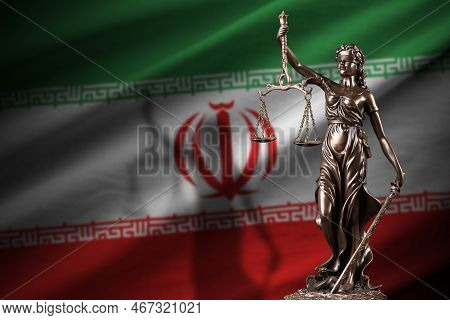 Iran Flag With Statue Of Lady Justice And Judicial Scales In Dark Room. Concept Of Judgement And Pun