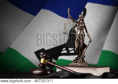 Lesotho Flag With Statue Of Lady Justice, Constitution And Judge Hammer On Black Drapery. Concept Of