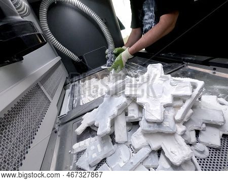 Male Worker Taking Out Models From White Polyamide Powder In Working Chamber Of 3d Printer, Cleaning