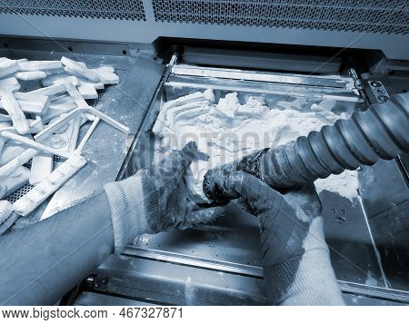 Male Worker Taking Out Models From White Polyamide Powder In Working Chamber Of 3d Printer, Cleaning