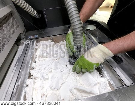 Mane Taking Out Models From White Polyamide Powder In Working Chamber Of 3d Printer, Cleaning And Re