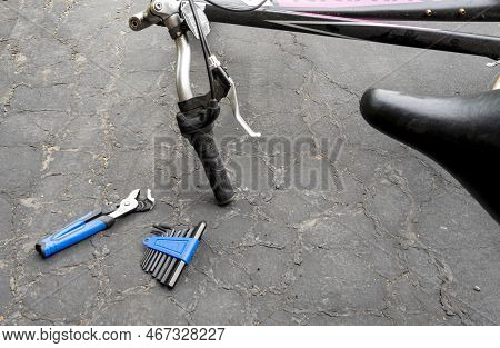 Older Bike And Screwdriver Set On Ground Next To It. Broken Bicycle Is Ready To Be Fixt