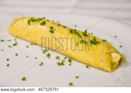 French Chives Omelette, Runny Or Baveuse Eggs With Green Herbs On A White Plate