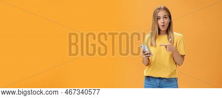 Wman Impressed By Wireless Earphones Connecting To Smartphone Themselves Pointing At Device Screen Q