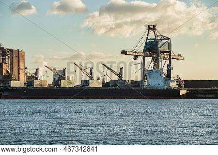 Rotterdam, Netherlands - November 11 2021 : Iron Ore Is Being Unloaded By Huge Cranes In Het Industr