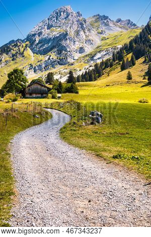 La Clusaz, France - August 20 2020 : The Gravel Road To A Historic Wooden Farm On The Alpine Meadows