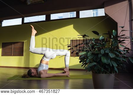 A Young Woman Leading A Healthy Lifestyle And Practicing Yoga, Performs The Ekapada Patihasana Exerc