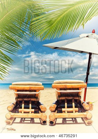 bamboe ligbedden zee en coconut palm tree over tropicl beach resort