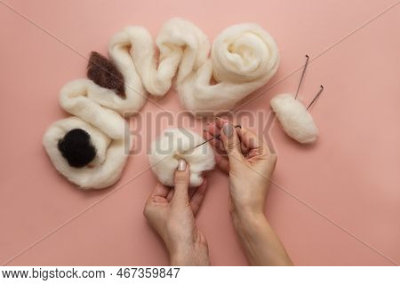 Woman Hand Holding Needle Felting Kit. Felted Woolen Needle And Skein Of Wool On Pink Table, Handicr