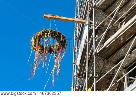 House With Scaffolding And Typical Greman May Pole Or Maibaum. Clear Blue Sky.