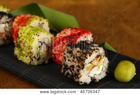 Velsmagende Maki sushi - Roll på måtten på brune baggrund