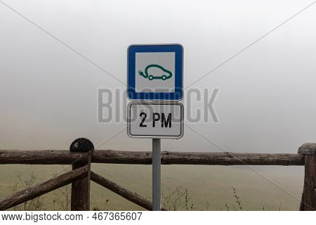 Parking Place For Electric Car And Sign For Charging In Winter In The Fog