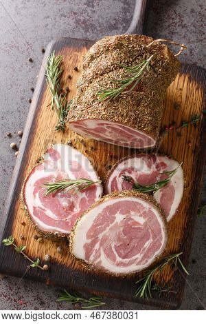 Closeup Of A Wooden Chop Board With Slices Of Italian Pancetta Closeup. Vertical Top View From Above