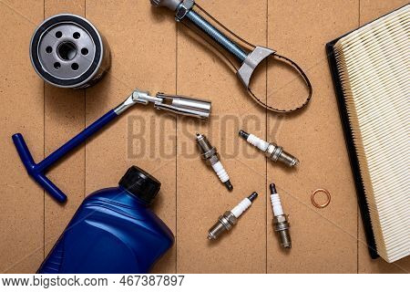 Bottle Of Motor Oil, Oil Filter, Air Filter, Sparking Plugs, Spark Plug Key And Oil Filter Wrench On