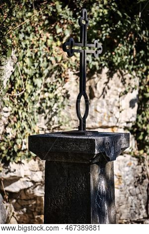 Talloires, France - September 08 2020 : An Historic Iron Cross On A Medieval Pillar Showing The Road