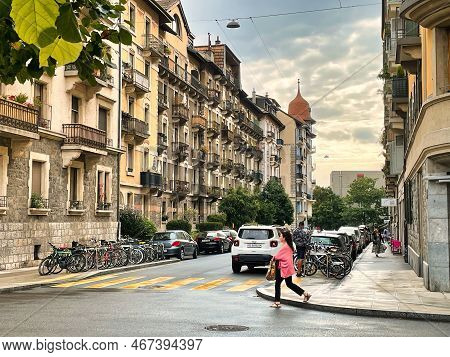 Geneva, Switzerland - September 15 2021: A Person Is Walking On The Sidewalk Near A Crossing With A 