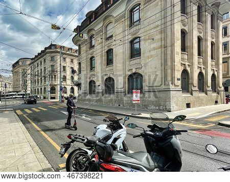 Geneva, Switzerland - September 15 2021: A Business Man In Suit Is Driving On The Strete In The Bank