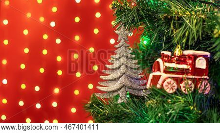 Christmas Decorations Hung On A Christmas Tree Against A Red Background.