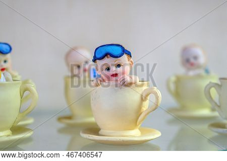 A Historical Porcelain Figurine. Porcelain Cup Little Porcelain Child With Glasses. Ancient Formatio