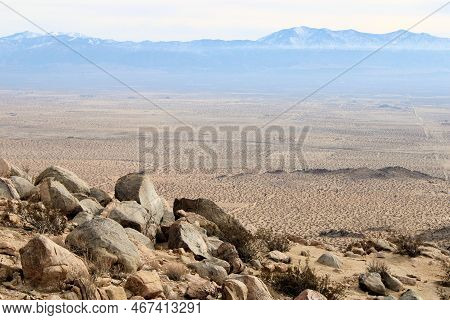 Granitr Rocks On A Mountain Ridge Overlooking The Desert Plateau With The Snow Covered San Gabriel M