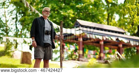 Senior Male Traveler Near Asian Temple. Adventure Is Ageless.