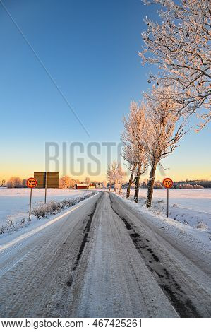 Icy Road Through Fields Covered In Snow