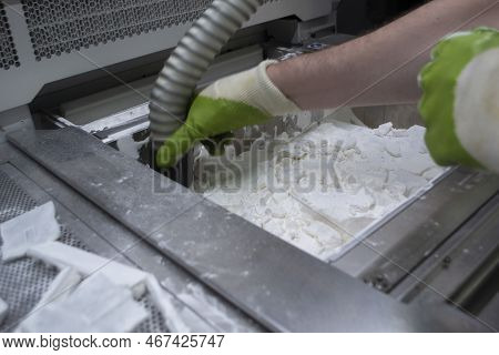 Mane Taking Out Models From White Polyamide Powder In Working Chamber Of 3d Printer, Cleaning And Re