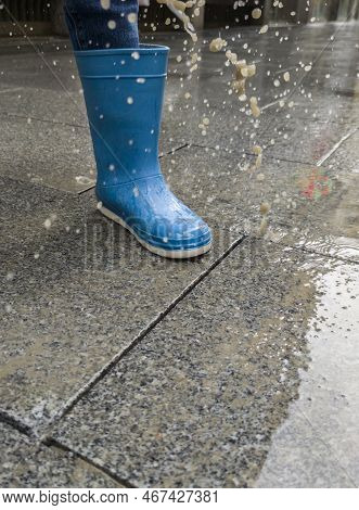 A Loose Cobblestone Splashes On A Childs Boots When Stepped On. High Speed Shooting