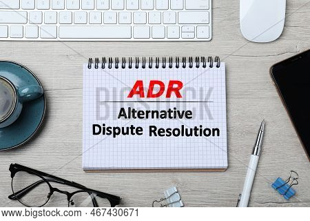 Notebook With Abbreviation Adr And Text Alternative Dispute Resolution On Wooden Table, Flat Lay. Mo