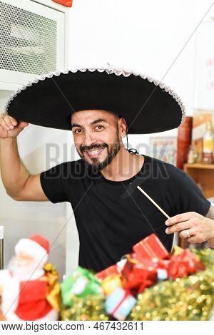 Mexican Man In Sombrero Holding Mustache On A Stick And Smiles In The Camera