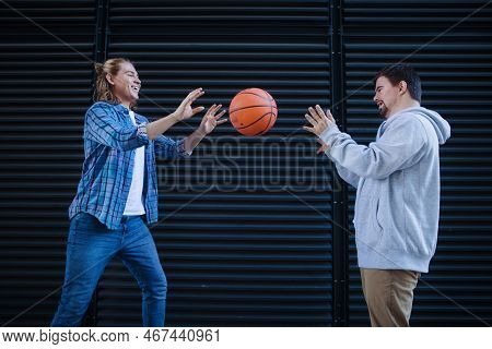 Man With Down Syndrome Playing Basketball Outdoor With His Friend. Concept Of Friendship And Integra