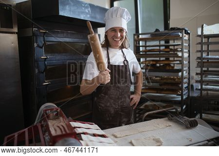 Young Baker With Chef Cap Preparing Pastries In Bakery.