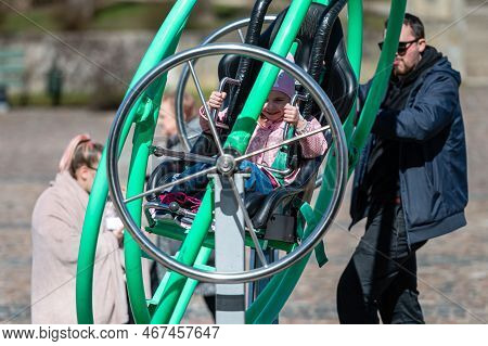 Dobele, Latvia - April 17, 2022: Kids Enjoy The Extreme Attraction Aerotrim - A Human Gyroscope With