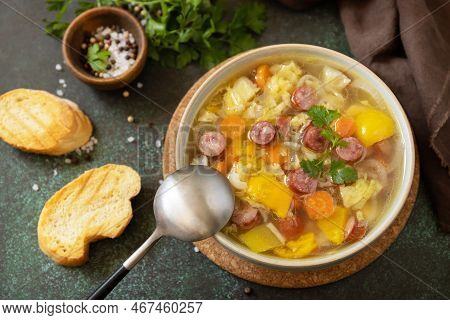 Traditional Zelnacka Cabbage Soup With Sausages And Vegetables In A Bowl On A Stone Tabletop. Czech
