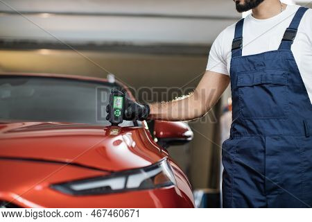 Closeup View Of Male Hand, Using Film Coating Thickness Gauge Device To Check Car Paint. Auto Coatin