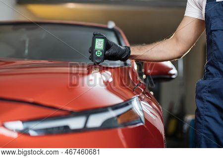 Closeup View Of Male Hand, Using Film Coating Thickness Gauge Device To Check Car Paint. Auto Coatin