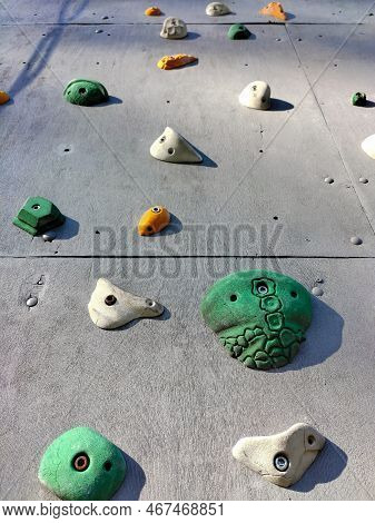 Close-up Of Hooks Of Different Shapes And Colors On A Wall For Sport Climbing Training