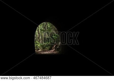 A View Looking Out From Iside Of A Tunnel