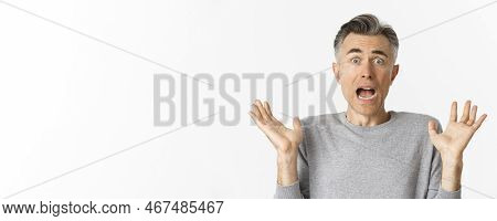 Close-up Of Scared Middle-aged Man, Looking Startled, Jumping And Screaming Frightened, Standing Amb